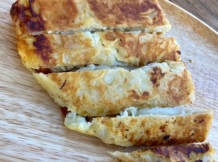 An overhead view of a borek sliced into pieces.