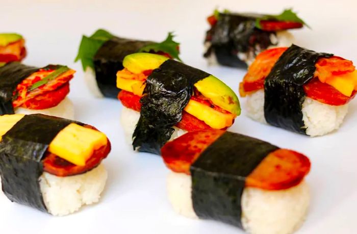 A selection of various musubis displayed against a white backdrop.