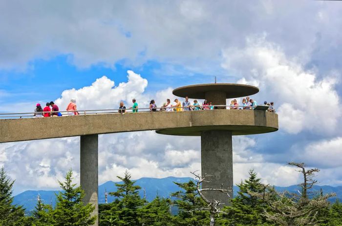 Visitors stroll along the concrete pathway of Clingmans Dome in Great Smoky Mountain National Park on a bright Tennessee day.