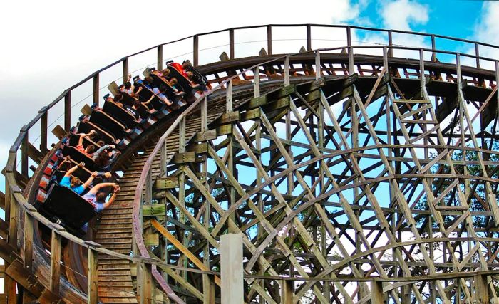 Guests throw their arms up in excitement on a wooden roller coaster at Dollywood in Pigeon Forge, Tennessee.