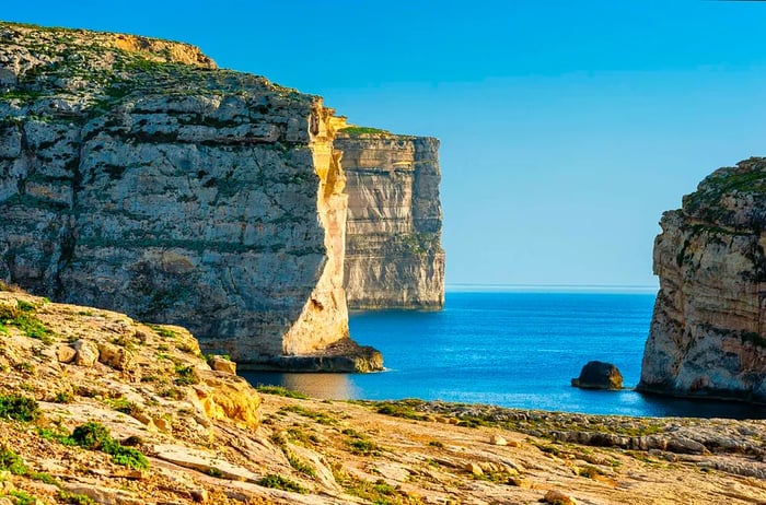 Sunlight illuminates the rocky cliffs of Gozo.