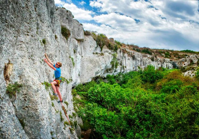 A climber ascends the cliffs at Mgarr ix-Xini in Gozo.