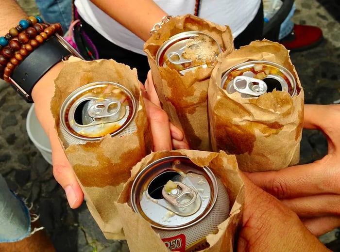 Cheers with beers nestled in brown paper bags, topped with little bits of salsa.