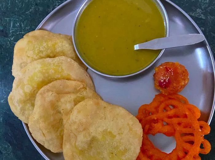 From above, a tray filled with amriti, darbesh, and lentils.