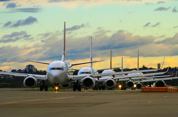 Aircraft lined up at sunset on the runway.