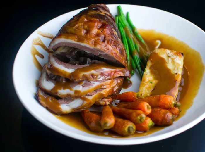 A generous portion of stuffed meat accompanied by roasted carrots.