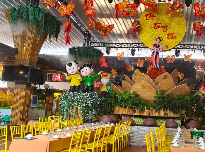 A whimsical restaurant interior featuring large, cartoonish child sculptures, faux greenery, and various decorations hanging from the lofty ceiling.