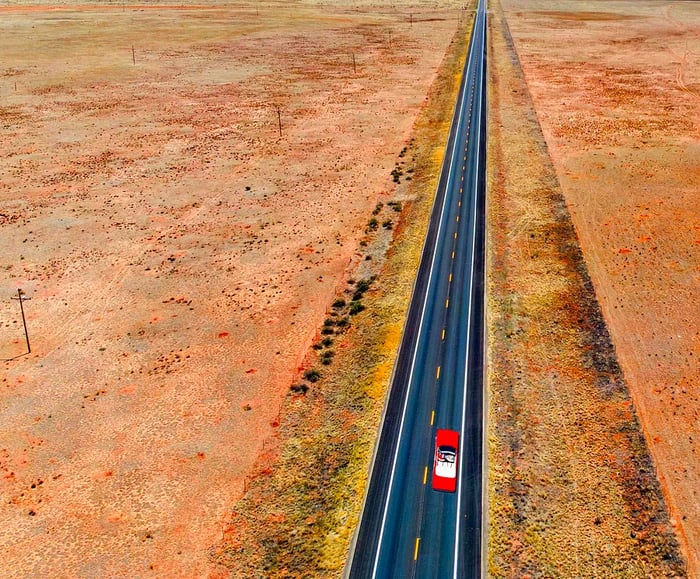 A red car cruising along Route 66 in the Arizona desert