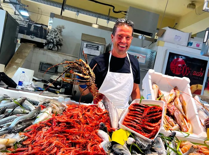 A fishmonger displays a stunning selection of seafood at a market stall.