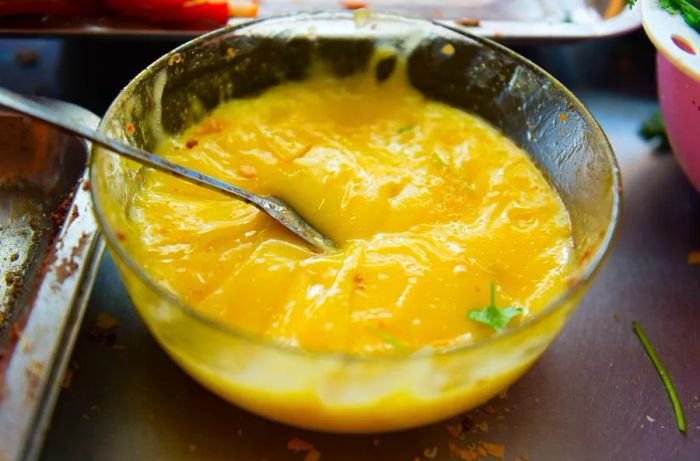 Vibrant yellow mayonnaise sitting in a large glass bowl.