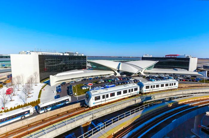 An AirTrain passes by the TWA Hotel at John F. Kennedy International Airport, Queens, New York City, USA