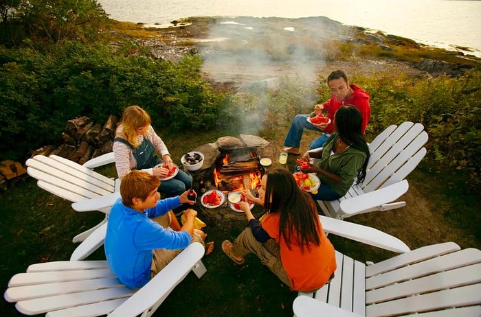 A group of friends grilling seafood over an open flame in Maine