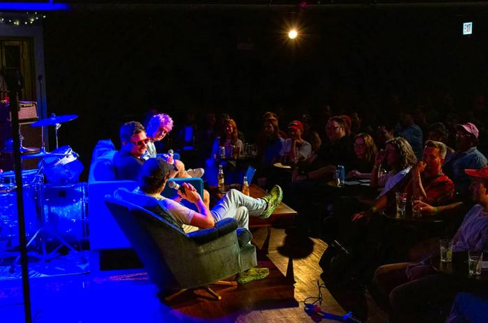 An audience enjoys a seated panel of performers at the iO improv theater