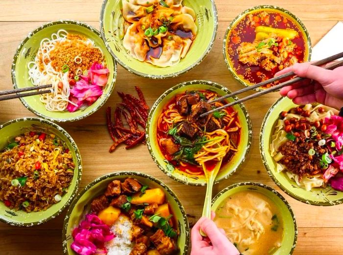 From above, patrons enjoy a variety of noodles, dumplings, and meat dishes.