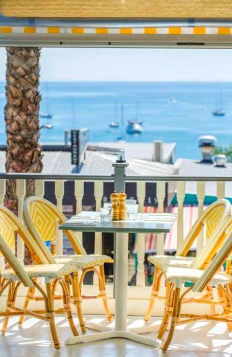 A four-person table on a patio with a water view.