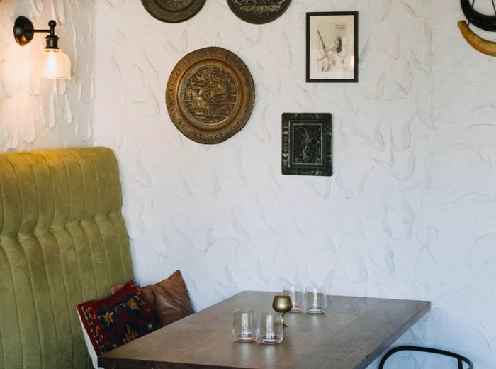 A dining space adorned with textured white walls, taxidermy, and an array of eclectic decorations.