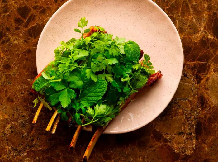 Ribs adorned with fresh greens from above.