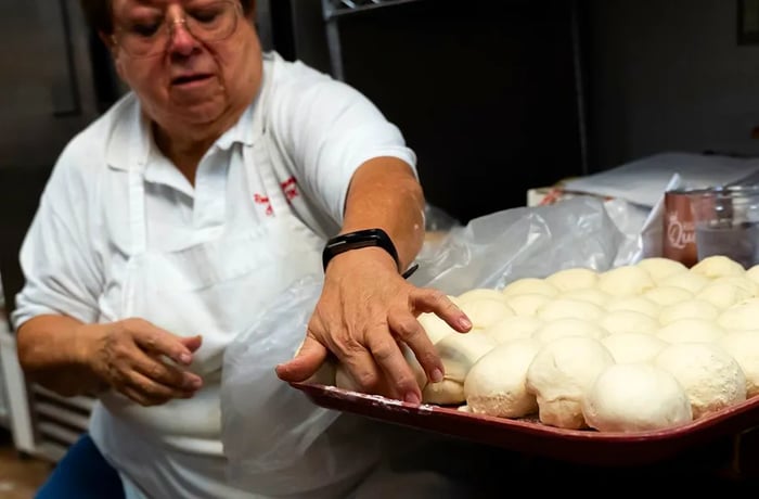 A cook forms balls of sopaipilla dough.