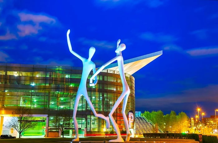 The Dancers public sculpture illuminated at night, in front of the Denver Performing Arts Complex.