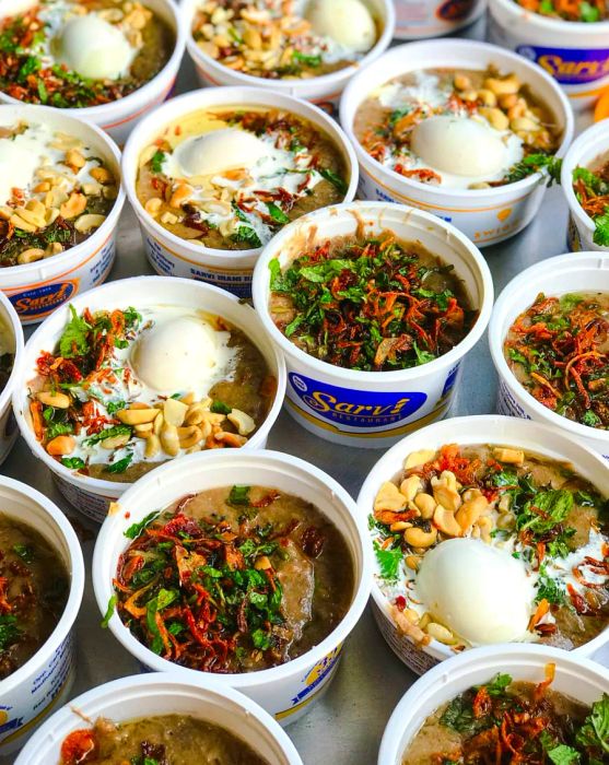 Bowls of haleem adorned with various toppings.