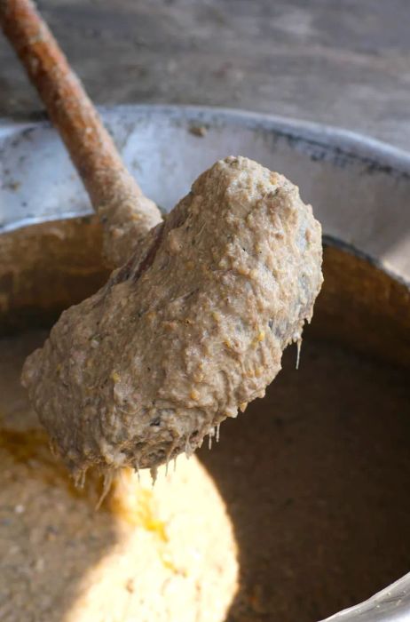 A hefty wooden mallet smeared with mashed haleem.