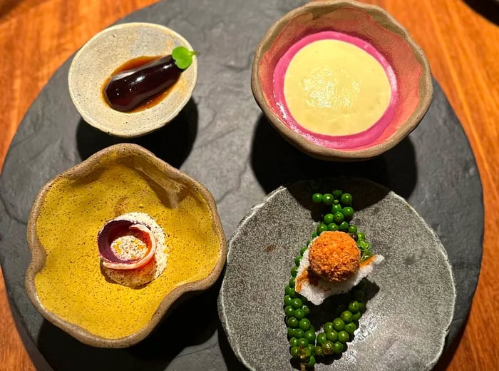 Four small plates elegantly arranged in decorative ceramic bowls.