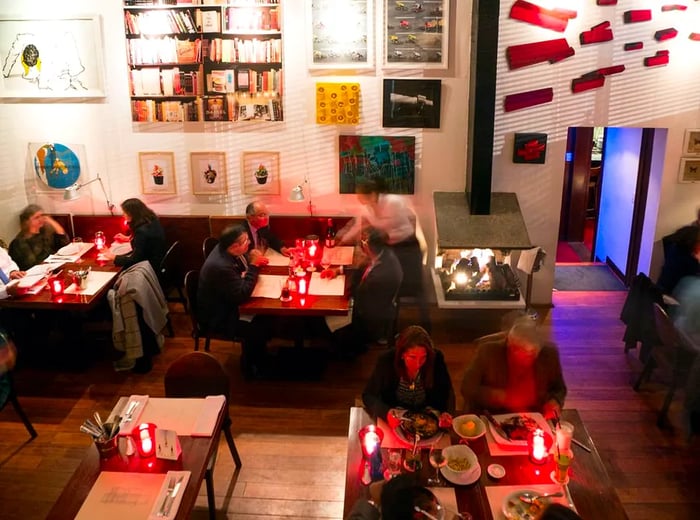 An overhead view of a spacious dining room filled with guests enjoying dinner at their tables.