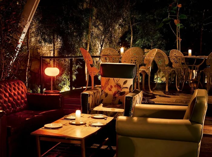 Cozy patio seating areas illuminated by soft lamps during the night.