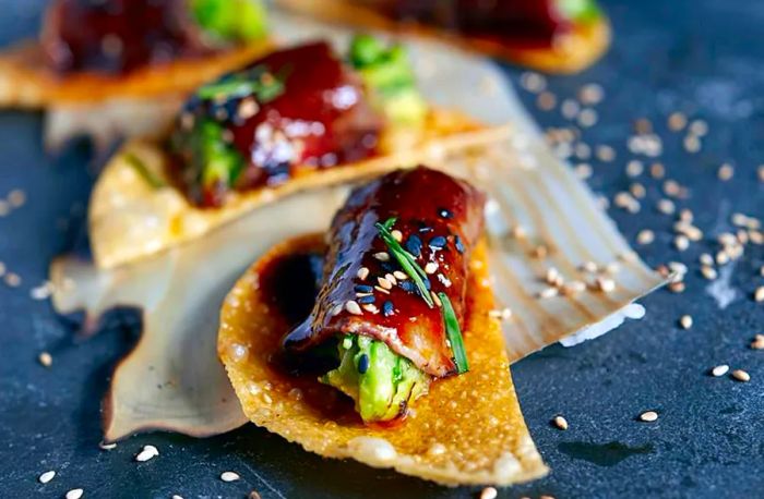 Vegetables wrapped in unagi served on a crispy wonton slice.