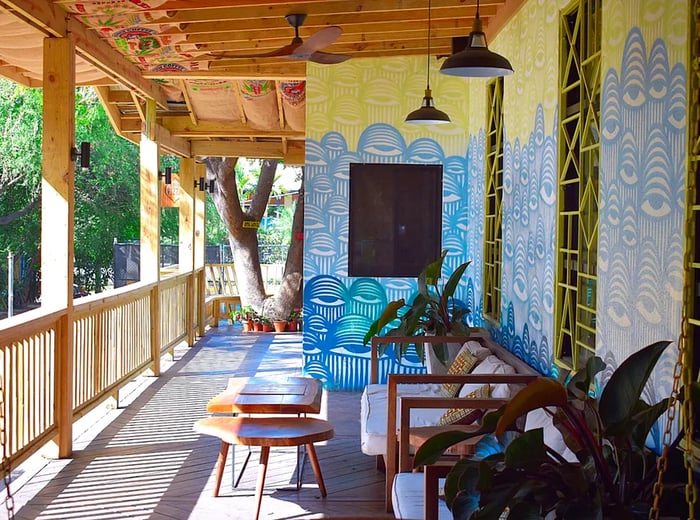 A cozy patio adorned with numerous couches and a striking mural.