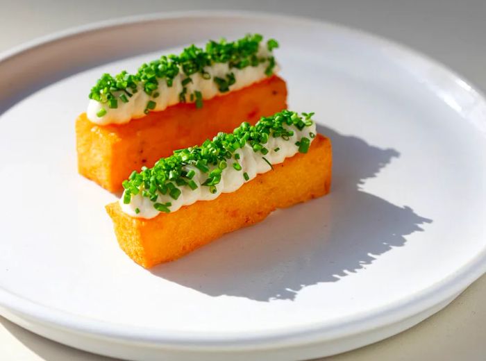 Chickpea fries garnished with taramasalata and chopped chives.