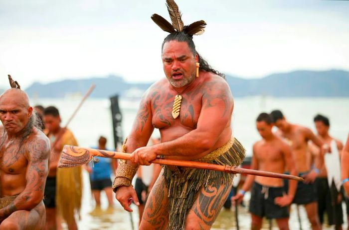 Māori warriors adorned with tattoos celebrate Waitangi Day, marking the anniversary of the Treaty of Waitangi between the British government and the Māori.