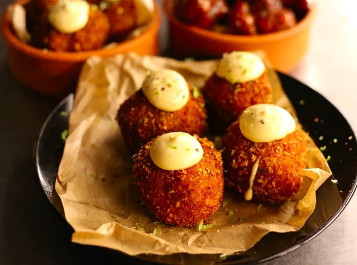 Two dishes featuring croquetas and grilled cauliflower.