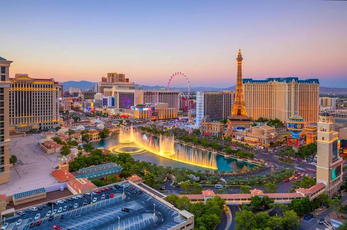 A vibrant cityscape filled with buildings surrounding a central avenue featuring grand fountains