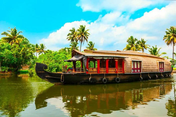 A houseboat gliding through the serene backwaters near Alappuzha in Kerala, India.