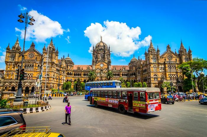 Two buses arrive at a majestic terminus in the city.