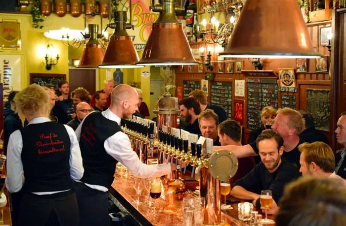 Inside, the bar buzzes with a lively crowd of patrons and staff dressed in waistcoats.