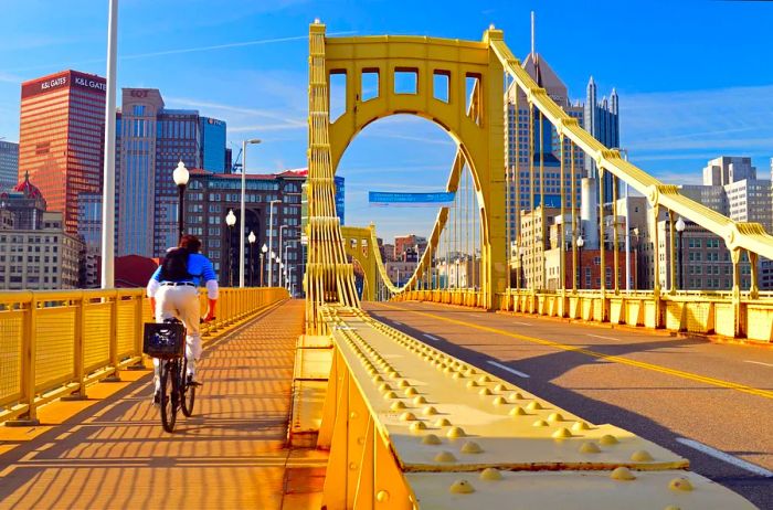 A young man rides his bike to work on the Roberto Clemente Bridge in Pittsburgh, Pennsylvania