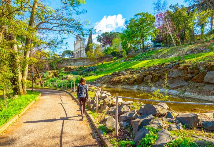 A woman strolls through the vibrant grounds of the Botanical Garden in Trastevere.