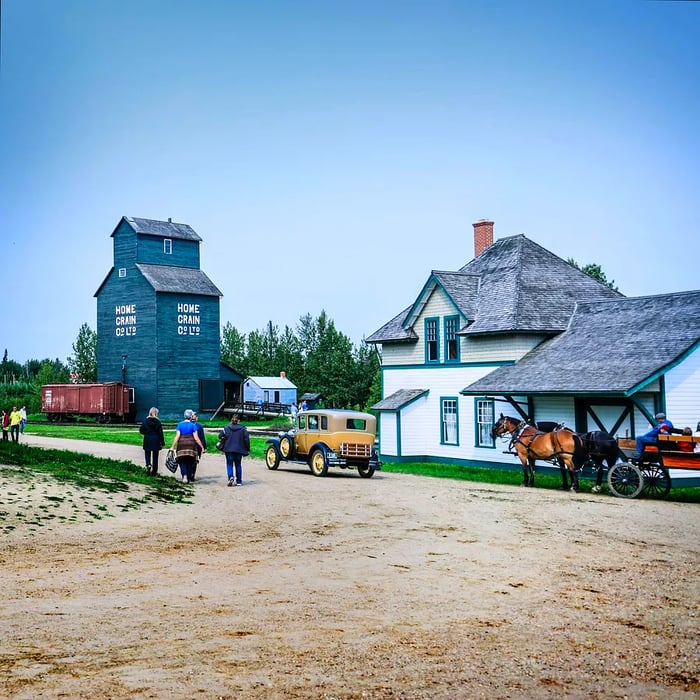 A quaint rural village featuring low-rise wooden structures and a horse-drawn cart.