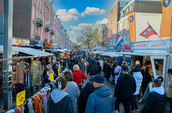 Visitors explore food stalls at Albert Cuypmarkt, Amsterdam, the Netherlands.