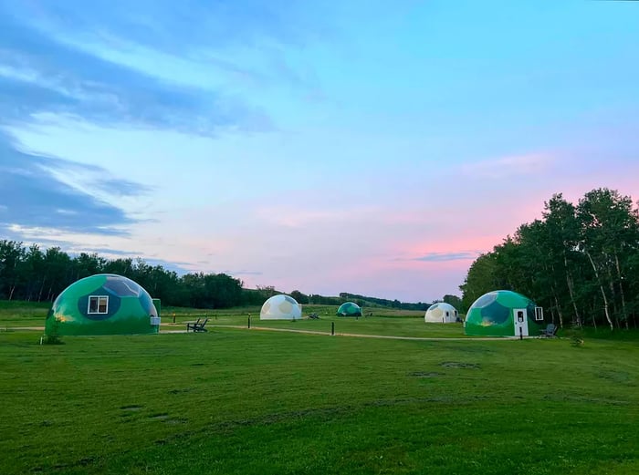 A field dotted with several domes ideal for stargazing