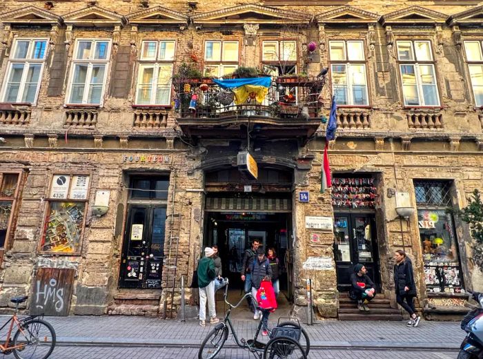 The exterior of a restaurant set within an ornate building, where patrons can be seen lingering outside.