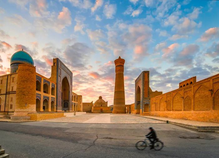 A cyclist passing by the Po-i-Kalyan Islamic monument in Bukhara, Uzbekistan