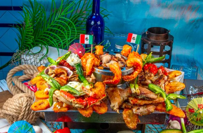 A seafood platter featuring shrimp, crab legs, plantains, and various sides, displayed against a backdrop of nautical-themed decorations.