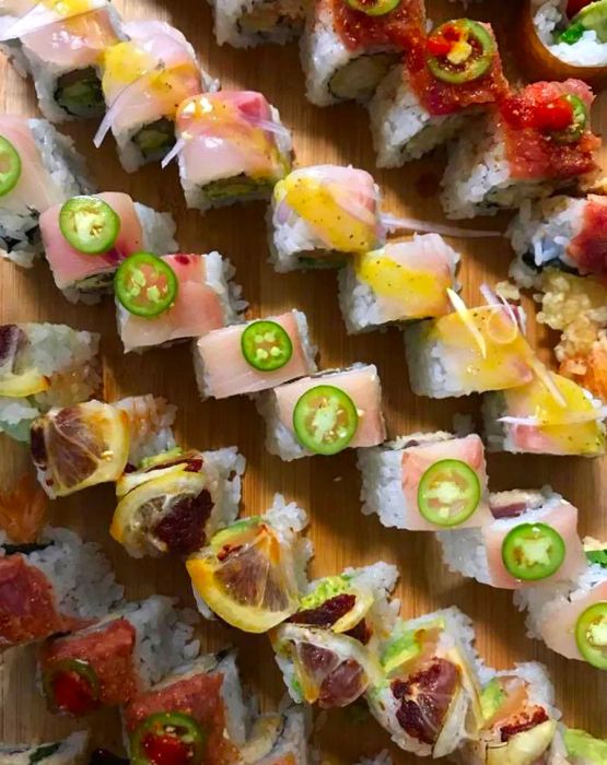 Sushi rolls elegantly arranged in diagonal lines, showcasing a variety of toppings.