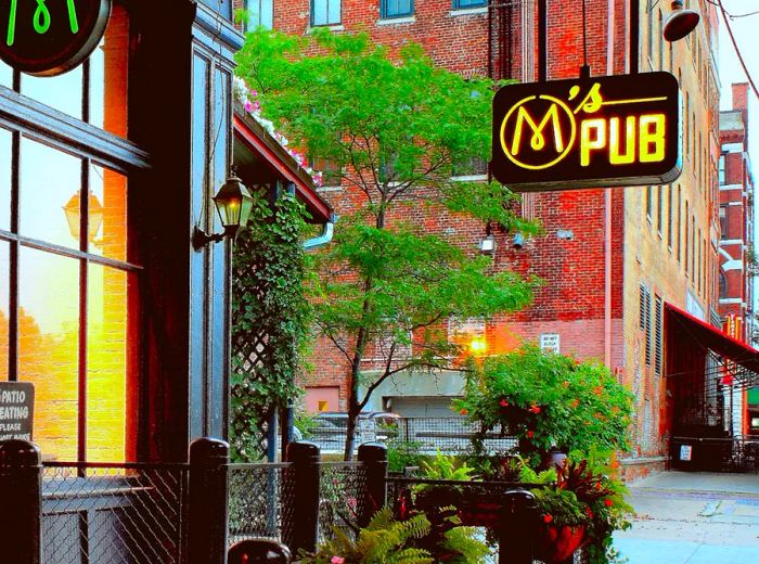 A charming red brick exterior adorned with greenery and a welcoming pub sign.