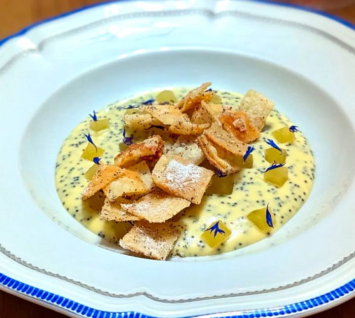 A broth-like dish adorned with rectangular crisps on top.