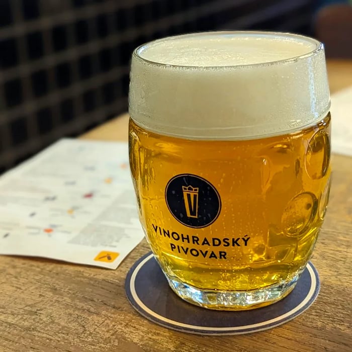 A branded glass brimming with beer.