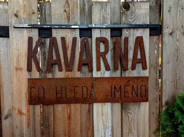 A wooden fence displaying the cafe's sign.